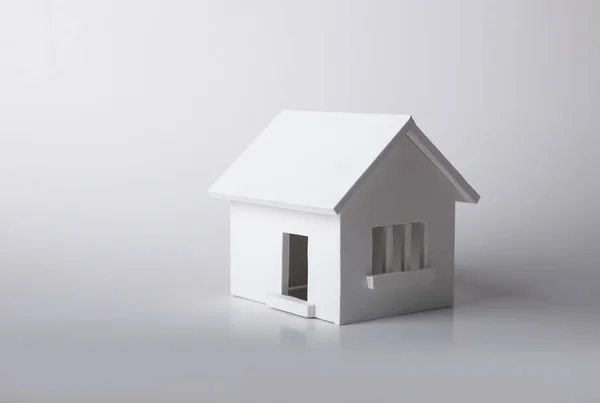 Дом зимой - концепция системы отопления и холодная снежная погода с моделью дома в вязаной шапке — стоковое фото