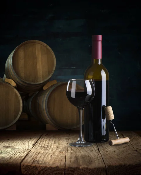 Red wine bottle and wine glass on wodden barrel — Stock Photo, Image