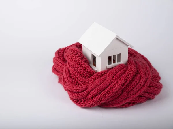 House in winter - heating system concept and cold snowy weather with model of a house wearing a knitted cap — Stock Photo, Image