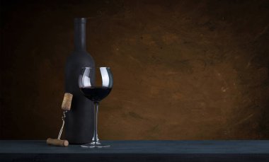 kırmızı şarap şişesi ve şarap kadehi yün fıçıda.