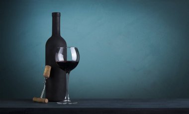 kırmızı şarap şişesi ve şarap kadehi yün fıçıda.