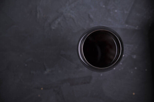Red wine glasses and bottle on stone background. Top view with copy space