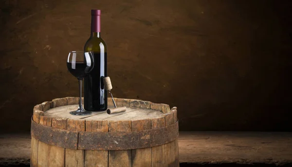 Red wine bottle and wine glass on wodden barrel Stock Picture