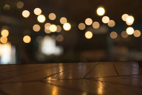 Obrázek dřevěný stůl před restaurace abstraktní rozmazané světla pozadí — Stock fotografie