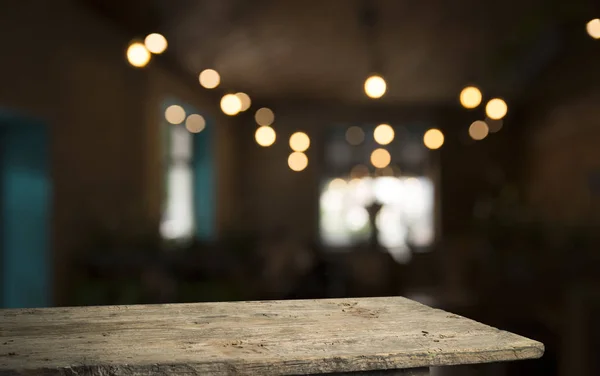 Empty wood table top on blur light gold bokeh of cafe restaurant in dark background — Stock Photo, Image