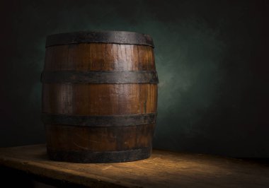 Bira fıçısı ve bira bardakları tahta bir masada. Koyu kahverengi arkaplan.