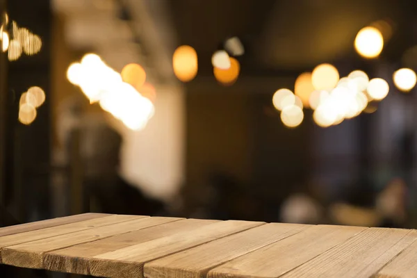 Prázdný hnědý dřevěný stůl a rozmazané pozadí abstraktní resturační světla lidé mají rádi jíst, mohou být použity pro montáž nebo zobrazení vašich produktů — Stock fotografie