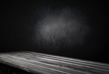 Seçili odak boş kahverengi ahşap masa ve duvar dokusu veya eski siyah tuğla duvar arkaplan bulanık görüntüsü. Fotomontaj ya da ürün gösterimi için