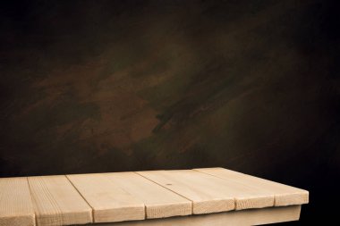 Seçili odak boş kahverengi ahşap masa ve duvar dokusu veya eski siyah tuğla duvar arkaplan bulanık görüntüsü. Fotomontaj ya da ürün gösterimi için