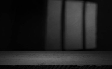 Karanlık oda arka planında bulanık beton duvar olan eski ahşap masa..