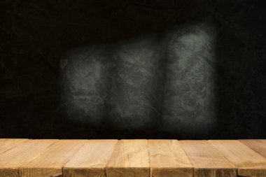 Karanlık oda arka planında bulanık beton duvar olan eski ahşap masa..