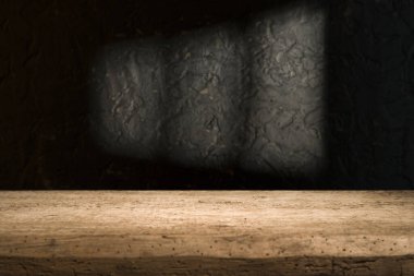 Karanlık oda arka planında bulanık beton duvar olan eski ahşap masa..