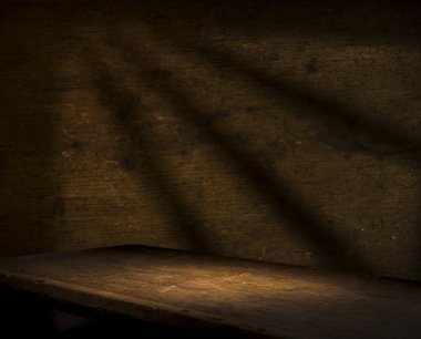 Karanlık oda arka planında bulanık beton duvar olan eski ahşap masa..