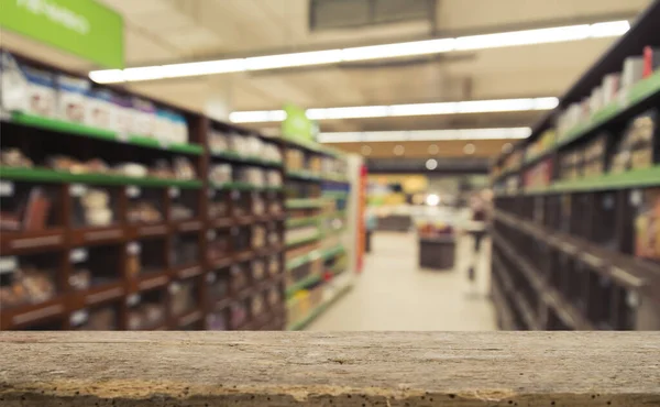 Supermarket background, Counter over blur grocery background, Wooden desk, table, shelf and blur woman shopping at supermarket, Wood counter for grocery store retail product display backdrop, template