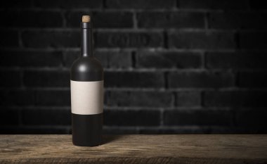 Şarap şişelerinin yanında duran barmen ya da erkek barmen bir bardak şarap tutuyor, renge bakıyor ve kadehteki şarap kokusunu alıyor..