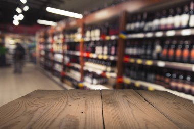 Süpermarket arka planı, bulanık market arkaplanı, ahşap masa, raf ve bulanık kadın süpermarketten alışveriş yapıyor marketin perakende satış için ahşap tezgah, dekor, şablon.