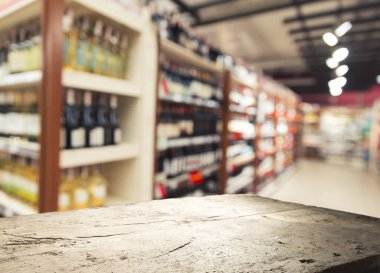 Süpermarket arka planı, bulanık market arkaplanı, ahşap masa, raf ve bulanık kadın süpermarketten alışveriş yapıyor marketin perakende satış için ahşap tezgah, dekor, şablon.