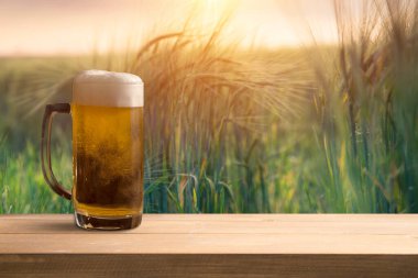 Gün batımında buğday tarlasının önündeki tahta masa. Ürün görüntüleme montajları için hazır