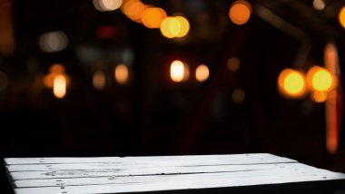 Koyu bulanık arkaplanı olan tahta masa.