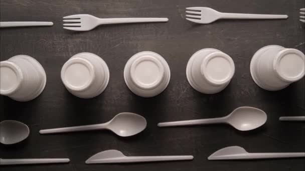 Plastic problem concept, stop motion animation, place for text, white plastic dishes move on black background — Stock Video