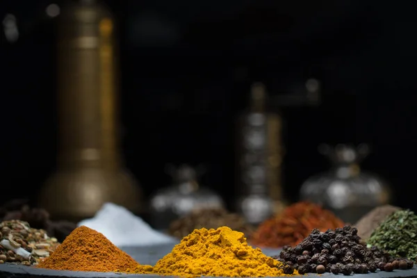 Oryantal yemeklerle çevrili koyu bir arkaplanda çeşitli baharatlar ve metin için boşluk.