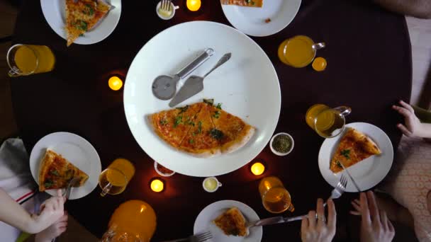 U kulatého stolu, rodina krájí pizzu, výhled shora, pět členů rodiny — Stock video