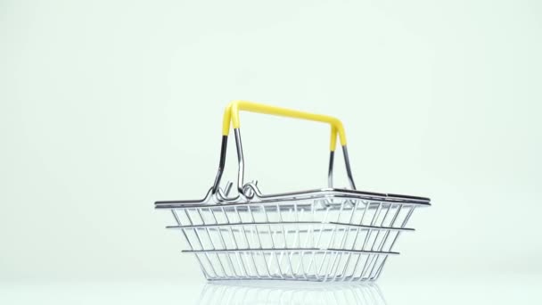 Supermarket basket with one dollar money rotates on a white background — Stock Video