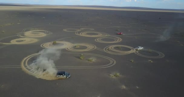 Автомобиль рисует круги в песчаном сугробе в пустыне — стоковое видео