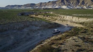 Arabalar ıssız bir yolda gidiyor.