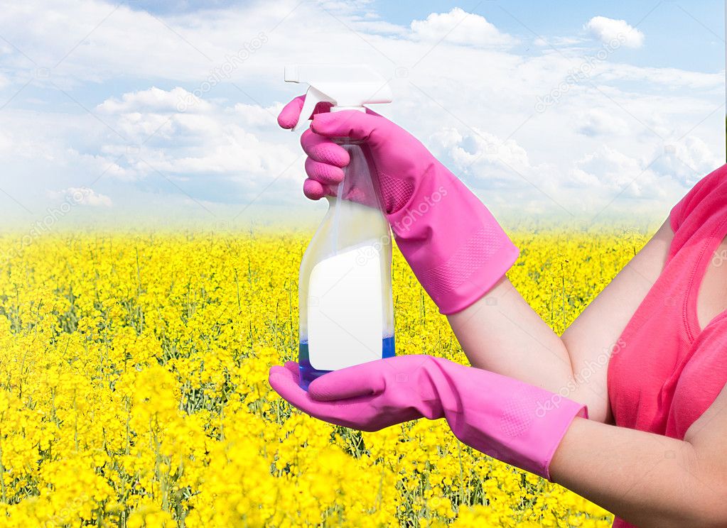 Cleaning product in the hands of the women on the background of flowers and sky