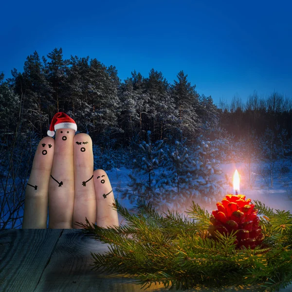 Finger art of friends celebrates Christmas. A group of people singing for Christmas in a forest.