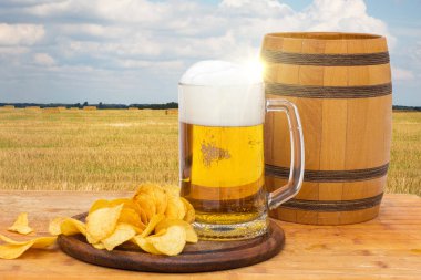 Fıçı bira ve cips kırsal arka plan üzerinde.