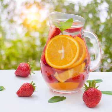 Aromatize su taze çilek ve cam sürahi içinde nane ile .