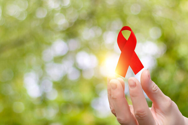 Ribbon for the fight against AIDS in the hands .