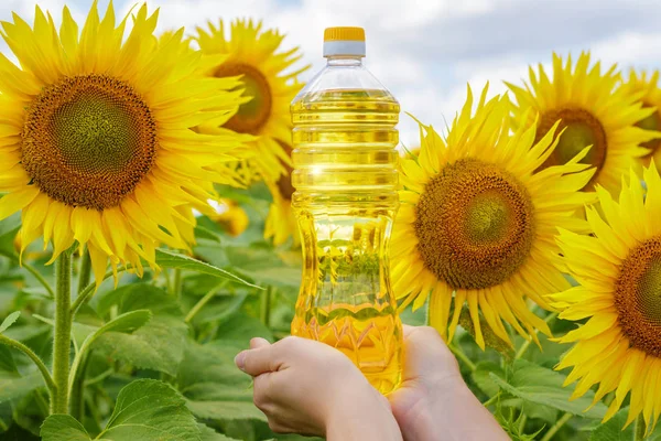 A bottle of sunflower oil on the background of sunflowers.