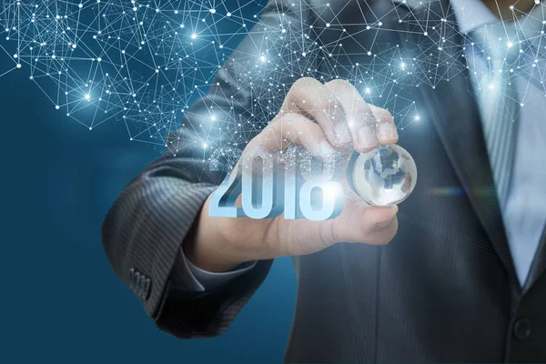 Bir arka plan üzerinde 2018 bir küre tutan el.