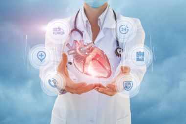 Sağlık çalışanı bir kalp elinde gösterir..