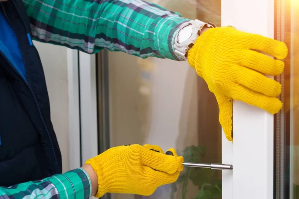 Maestro con destornillador reparando una ventana . — Foto de Stock