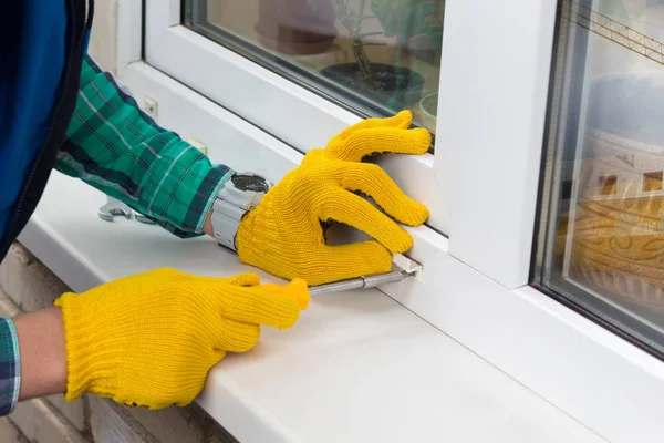 Trabajador con destornillador reparando una ventana . — Foto de Stock