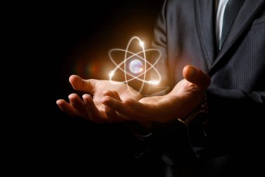 Koyu arka plan üzerinde elinde atom.