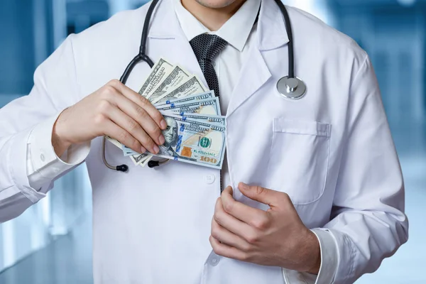 医生把贿赂的钱藏在旁边的口袋里 . — 图库照片