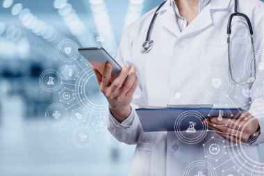 Tıbbi hizmetlerin sağlanmasında mobil cihazlara yardım etme kavramı. Doktor arka planda bulanık bir cep telefonunda çalışıyor..