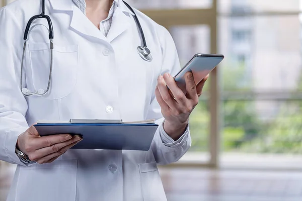 A doctor is studying a medical history using a mobile device.