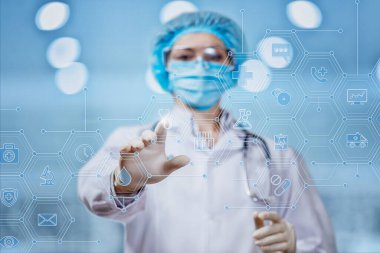 Teşhis ve tedavi kavramı. Doktor bulanık bir arkaplanda steteskop simgesine tıklıyor..
