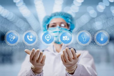 Tıbbi çağrı merkezi desteği kavramı. Doktor bulanık bir arkaplanda tıbbi bakım ve kontakt simgeleri gösteriyor..