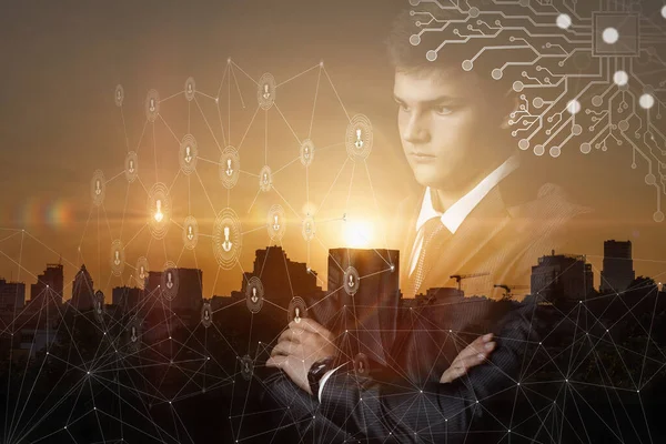 Young businessman analyzes the network on a background of city sunset.