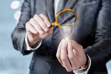 İş adamı bulanık bir arkaplanda sanal ağ korumasını inceliyor.