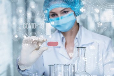 Doktor bir koronavirüs örneği testi uygular. Doktor tıbbi bir numuneye bakıyor..