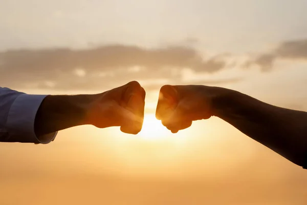 ビジネスにおける協力とチームワークの概念 太陽を背景にビジネスマンの2人の拳 — ストック写真