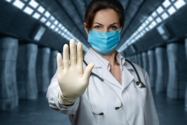 Virüsü Durdur konsepti. Doktor, arka planda bulanık elle yasaklama işareti gösteriyor..